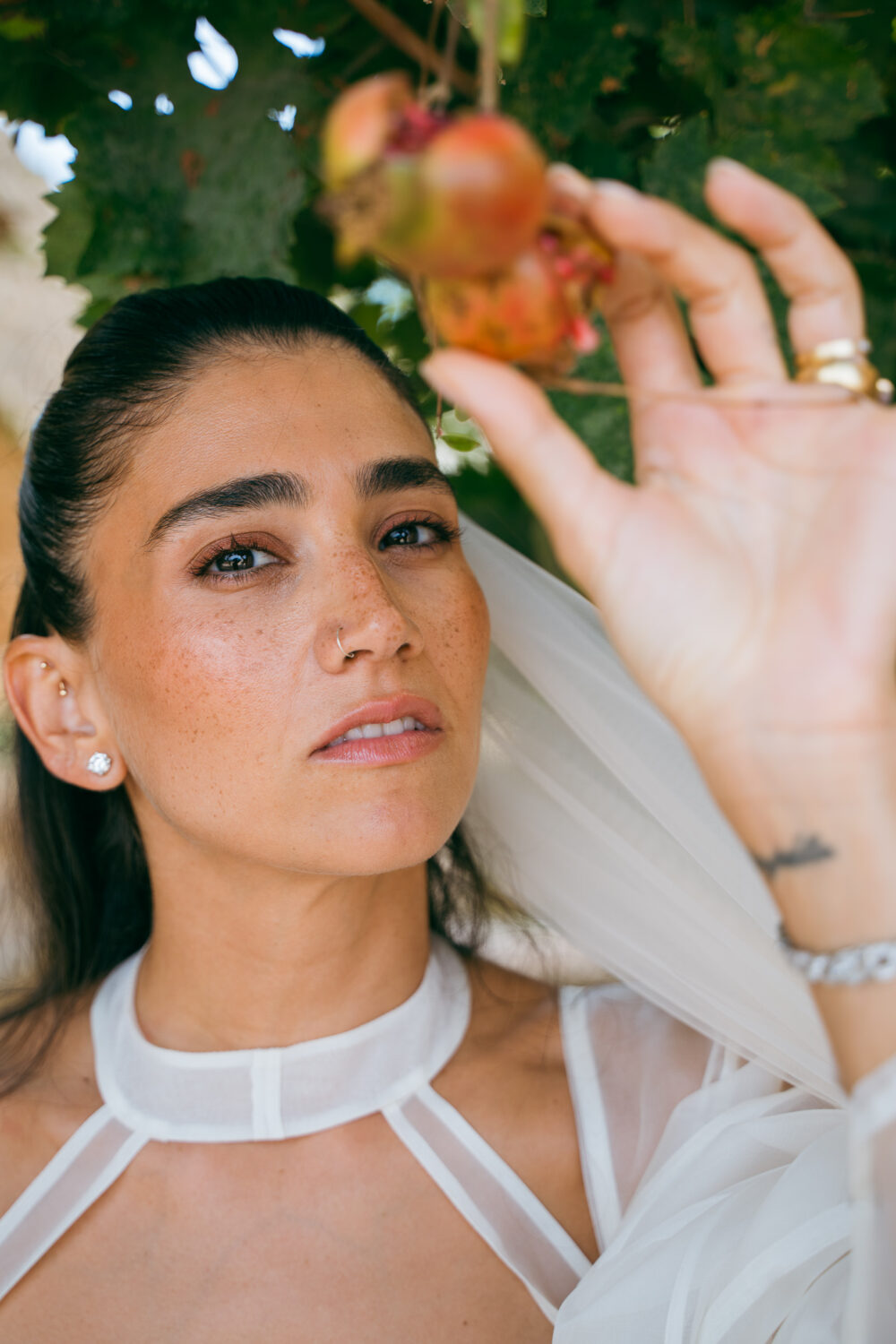 Masseria San Paolo Grande Wedding: Yasemin & Omer's Ostuni Celebration 40 Bride holding a pomegranate branch in the estate's gardens at Masseria San Paolo Grande