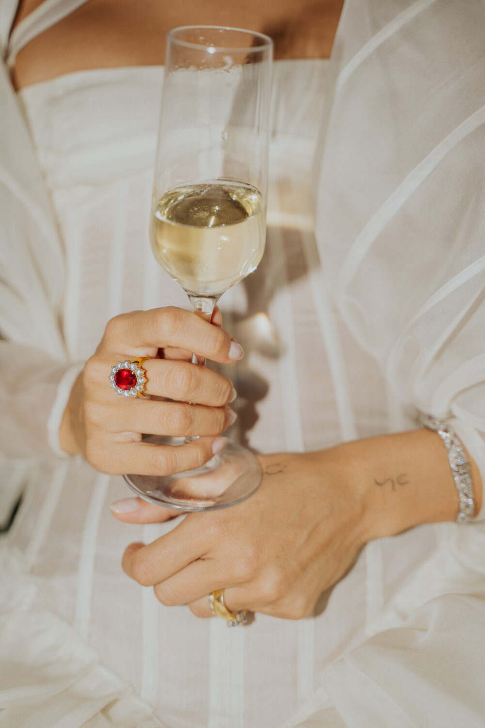 Masseria San Paolo Grande Wedding: Yasemin & Omer's Ostuni Celebration 59 Detail of the bride's rings with a glass of champagne during the reception