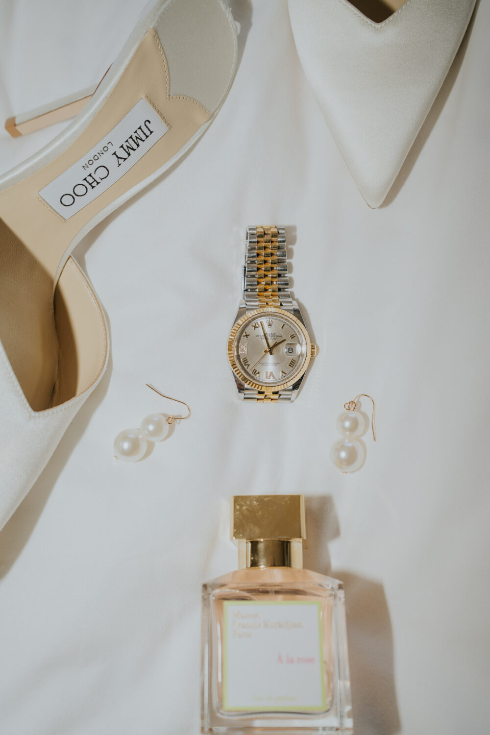 Bride's ivory Jimmy Choo wedding shoes and perfume styled on the bed