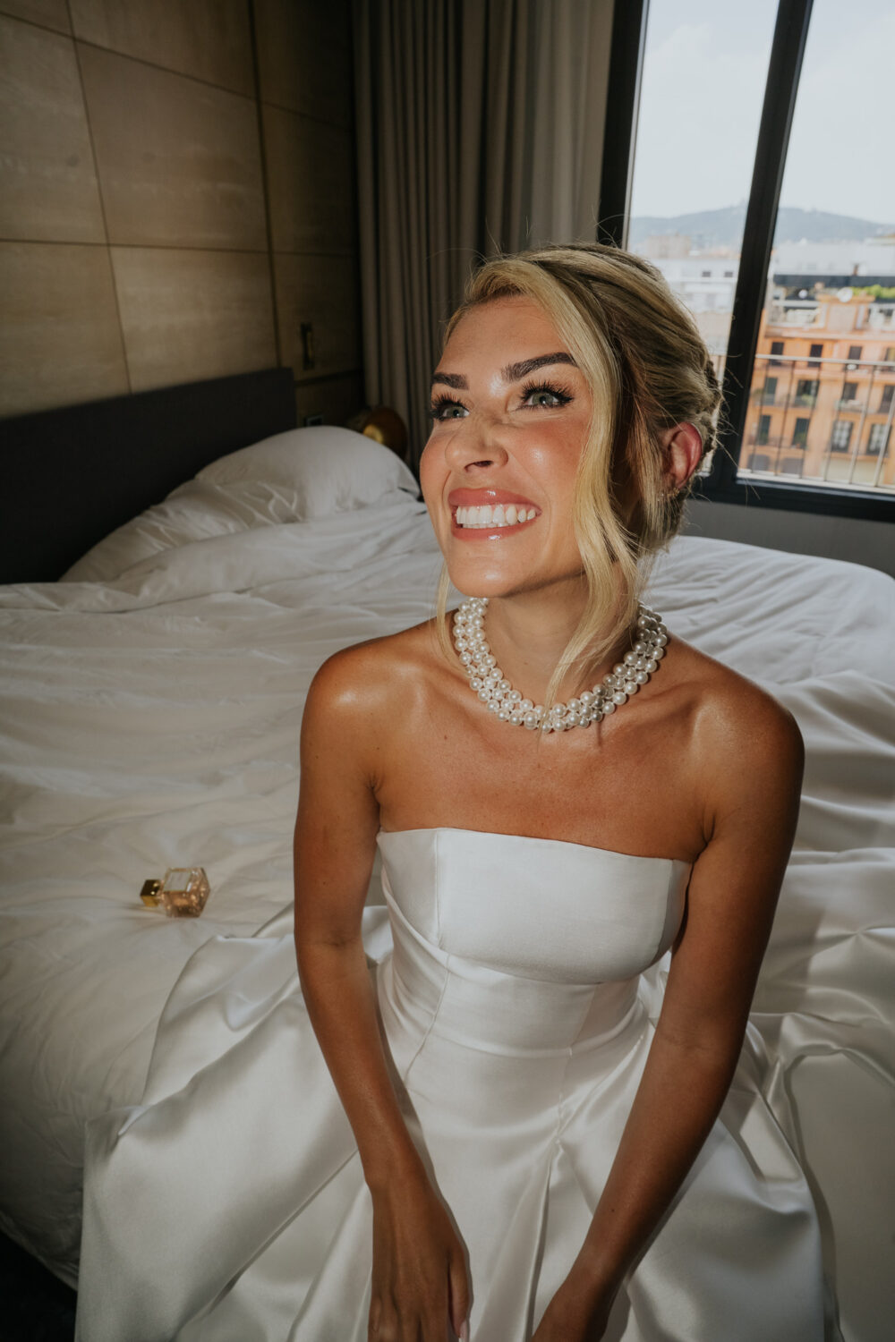 Close-up of the bride's hands on her satin wedding gown showing her engagement ring
