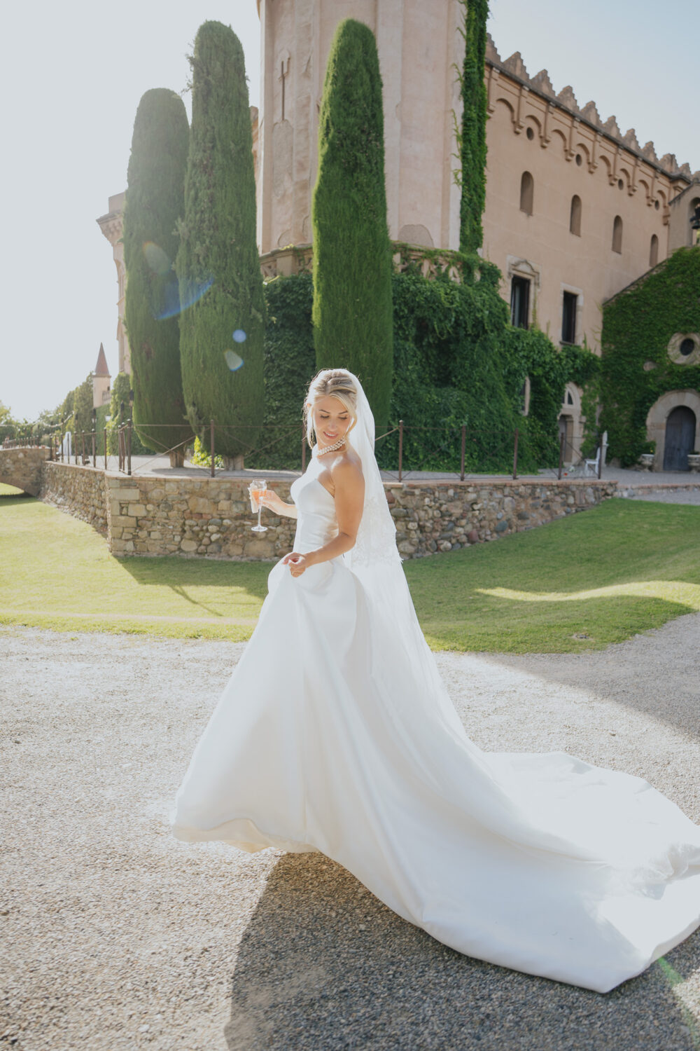 Bride and groom kissing under her lace-edged veil outside the castle wall