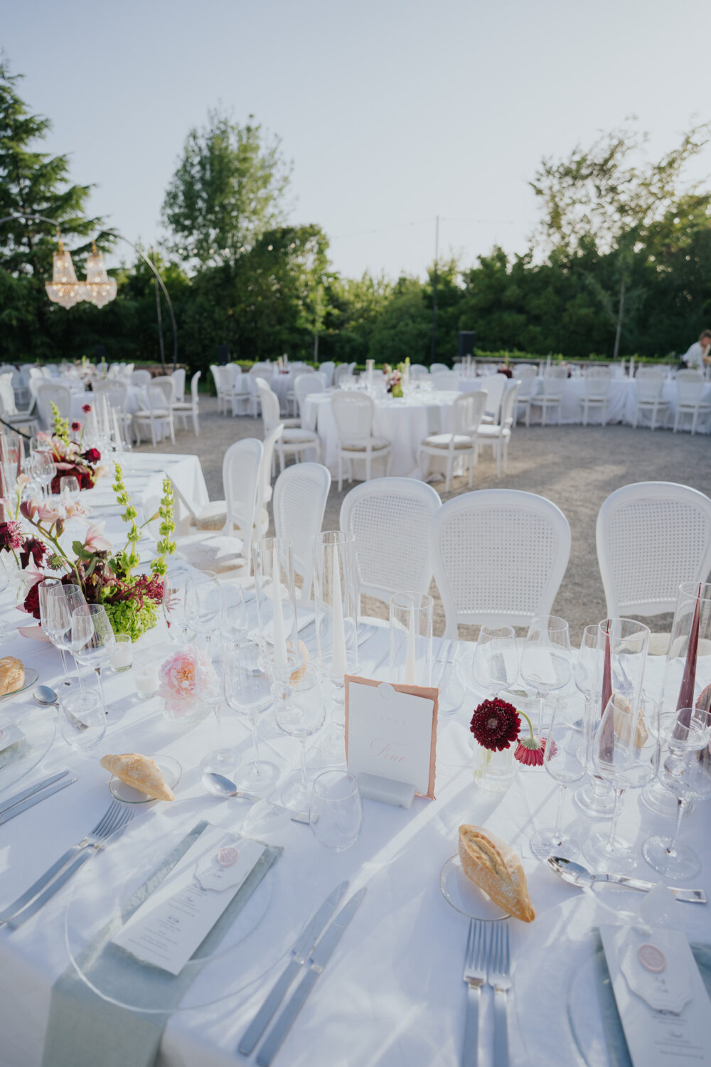 Bride and groom pouring champagne into a glass tower with the castle behind them