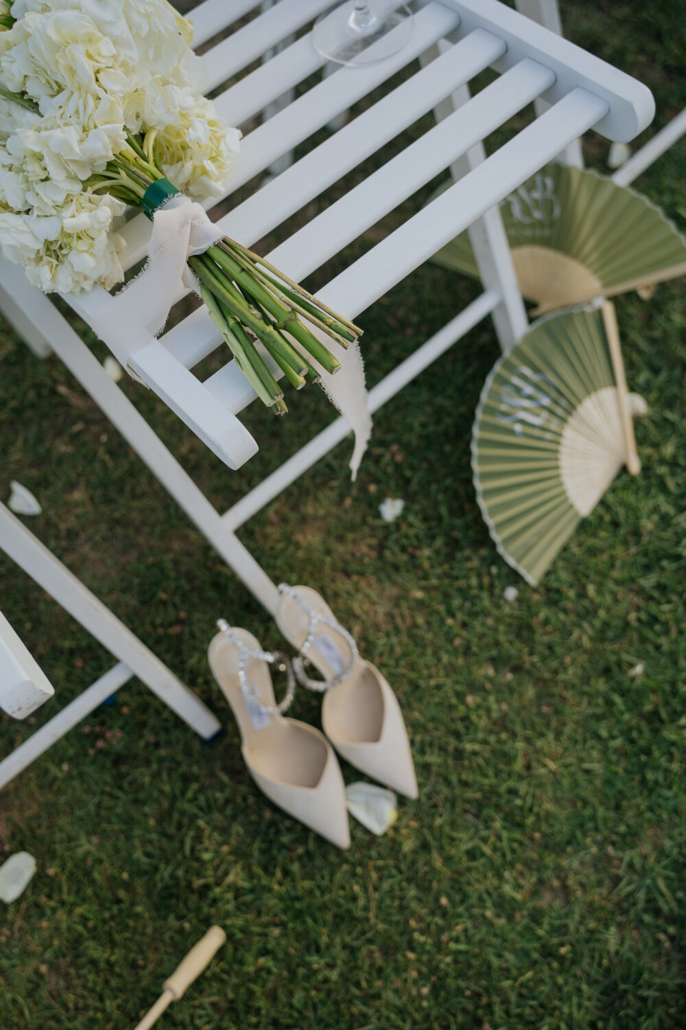 Wedding seating chart display beside white parasols and hydrangea florals